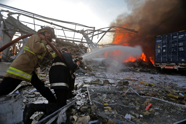 Lebanese firefighters extinguish fire at the scene of an explosion at the port in the capital Beirut on Tuesday (AFP photo)