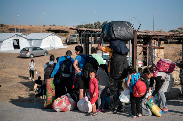 Migrants wait to register to enter a new temporary camp where refugees and migrants from the destroyed Moria camp will be accommodated in Mytilene on the Greek island of Lesbos on Saturday (AFP photo)