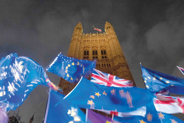 In this file photo taken on October 21, 2019 EU and Union flags flutter in the breeze as Pro and anti-Brexit demonstrators protest outside the Houses of Parliament in central London. According to a British government source a 'deal is done' on post-Brexit trade (AFP photo)