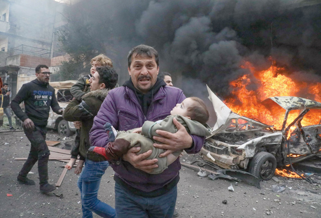 Civilians carry a young victim at the scene of an explosion in the town of Azaz in the rebel-controlled northern countryside of Syria's Aleppo province,on Friday (AFP photo)
