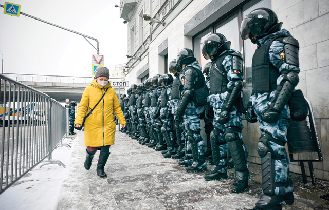 A woman walks in front of riot police during a rally in support of jailed opposition leader Alexei Navalny in Moscow on Sunday (AFP photo)