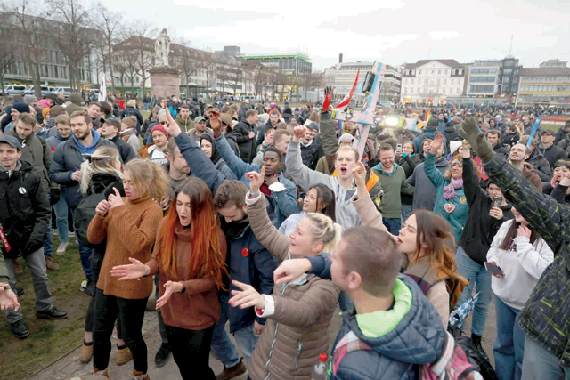 Protesters dance at the end of a demonstration demanding the compliance of basic rights and an end of the restrictive coronavirus measures in Kassel, central Germany, on Saturday (AFP photo)