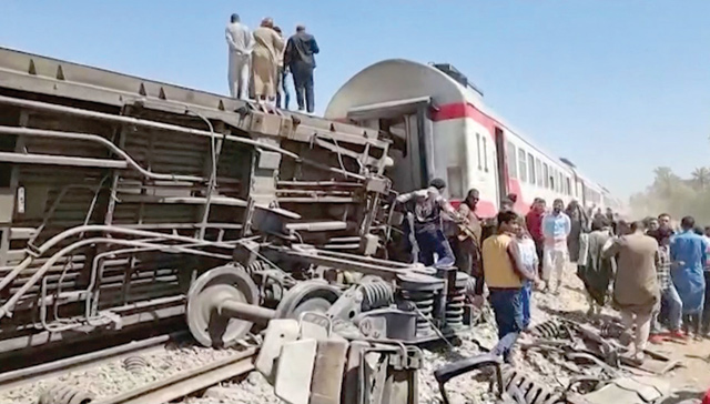 This screengrab provided by AFPTV shows people gathered around the wreckage of two trains that collided in the Tahta district of Sohag province, some 460 km south of the Egyptian capital Cairo, reportedly killing at least 32 people and injuring scores of others, on Saturday (AFP photo)