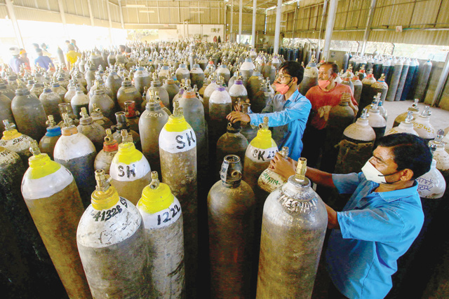Workers prepare to fill medical oxygen cylinders for hospital use on Covid-19 coronavirus patients on the outskirts of Jabalpur on Sunday (AFP photo)