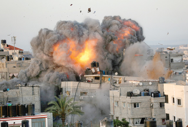 A ball of fire erupts from a building in Gaza City's Rimal residential district on Sunday, during massive Israeli bombardment on the Hamas-controlled enclave  (AFP photo)
