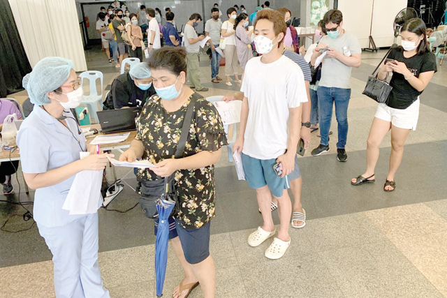 People queue to register for the second dose of China's Sinovac COVID-19 coronavirus vaccine in the hall of the Holy Redeemer Church in Bangkok on Saturday (AFP photo)