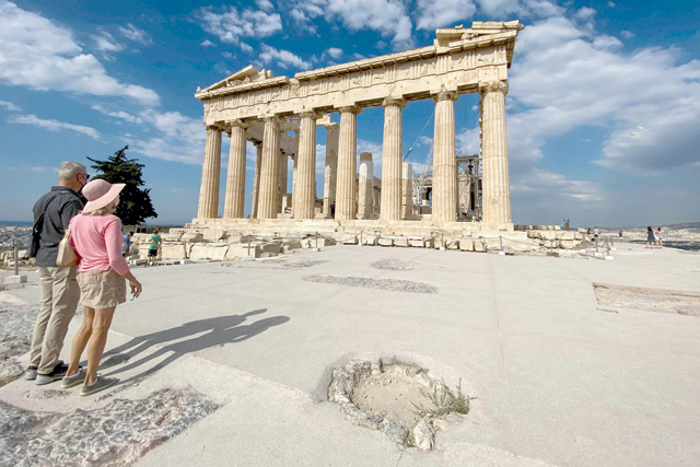 Tourists stand in front of the ancient temple of Parthenon on the Acropolis hill in Athens, on June 4 (AFP photo)
