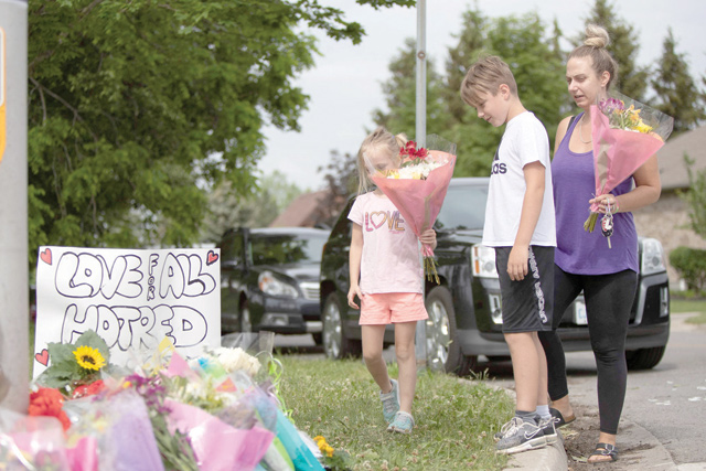 Families pay their respects on Tuesday, at a makeshift memorial near the site where a man driving a pick-up truck struck and killed four members of a Muslim family in London, Ontario, Canada (AFP photo)
