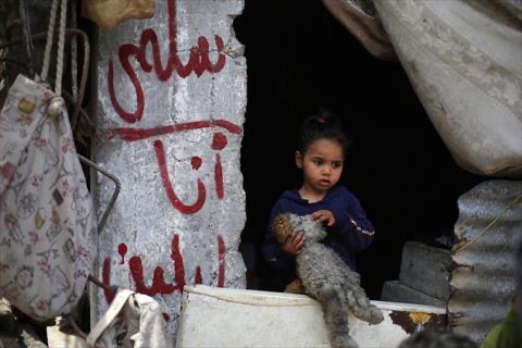 Caption:    A girl stands near graffiti on a concrete pillar with names of Palestinian father Wissam Wishah's children, Said, Salma, and Eline who were killed in Israeli strikes in the vicinity of their home, at their heavily damaged house at the Al Bureij refugee camp in the central Gaza Strip on May 1, 2025 (AFP photo)
