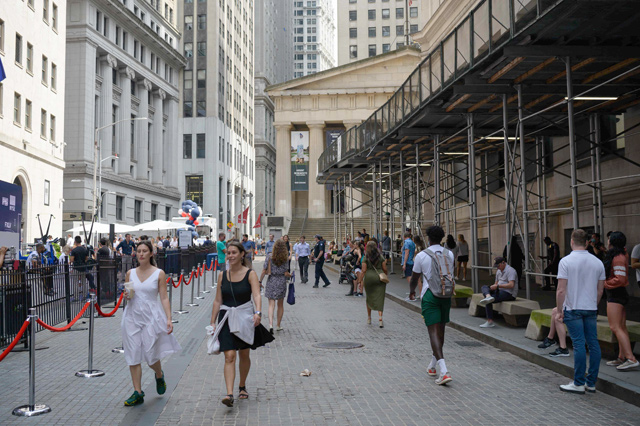 This photo shows people walking past the New York Stock Exchange on Wall Street on Thursday in New York City (AFP photo)