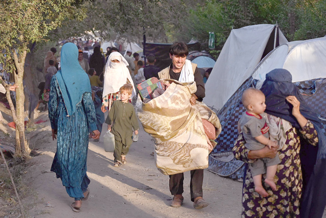 Internally displaced Afghan families, who fled from Kunduz, Takhar and Baghlan province due to battles between Taliban and Afghan security forces, walk in front of their temporary tents at Sara-e-Shamali in Kabul on Wednesday (AFP photo)
