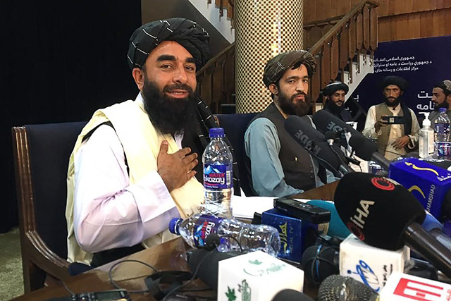 Taliban spokesperson Zabihullah Mujahid (left) gestures as he arrives to hold the first press conference in Kabul on Tuesday following the Taliban's stunning takeover of Afghanistan (AFP photo)