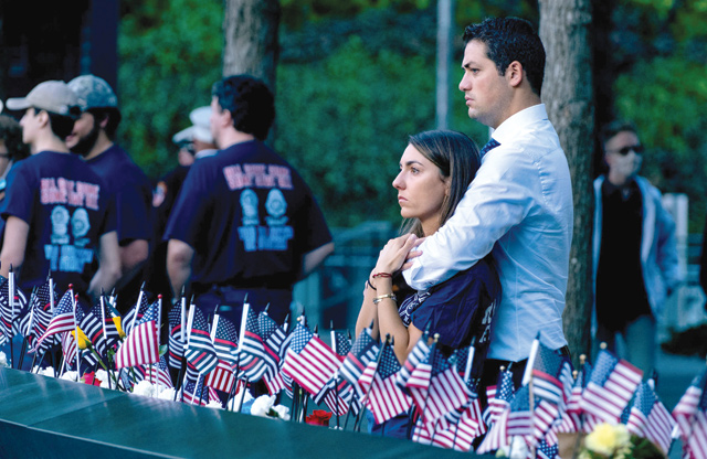 Katie Mascali is comforted by her fiance Andre Jabban as they stand near the name of her father Joseph Mascali, with FDNY Rescue 5, during ceremonies on Saturday, marking the attacks on the World Trade Centre in Manhattan (AFP photo)