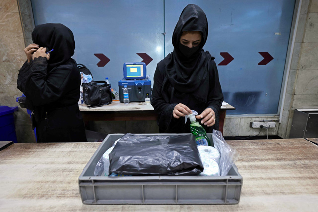 Afghan women airport workers are pictured at a security checkpoint of the airport in Kabul on Sunday. Of the more than 80 women working at the airport before Kabul fell to the Taliban on August 15, just 12 have returned to their jobs (AFP photo)