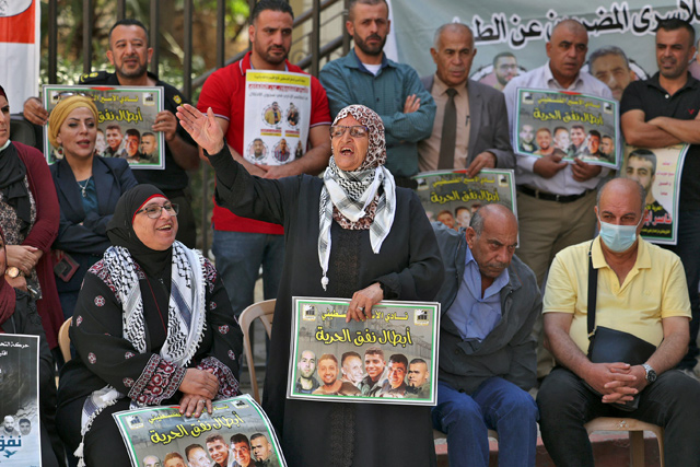 A protester chants slogans as people gather with signs for a demonstration in support of Palestinian prisoners held in Israeli prisons, outside the offices of the International Committee of the Red Cross in Ramallah in the occupied West Bank, on Tuesday (AFP photo)