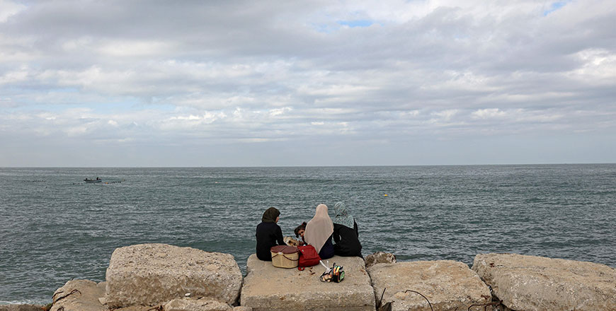Palestinian women sit together at the seaport of Gaza City on Monday (AFP photo by Mohammed Abed)