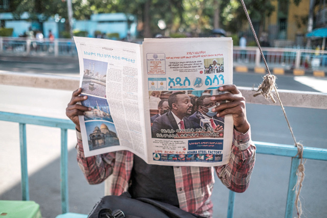 A man holds a newspaper depicting a photo of Ethiopian Prime Minister Abiy Ahmed, in a downtown area of the city of Addis Ababa, Ethiopia, on Wednesday (AFP photo)