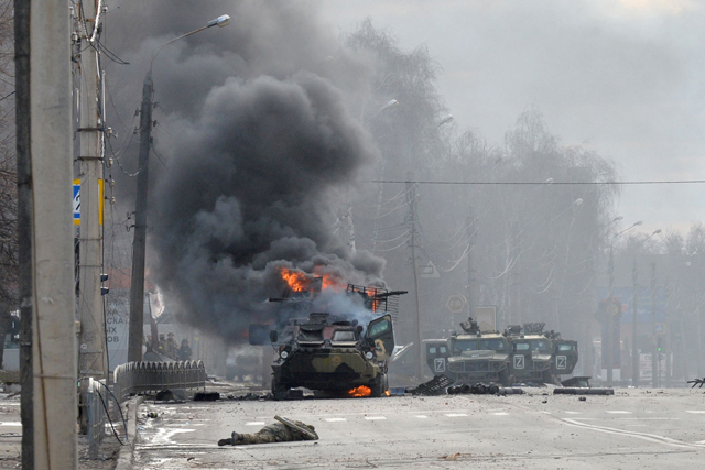 This photo taken on Sunday shows a Russian armoured personnel carrier burning next to unidentified soldier's body during fight with the Ukrainian armed forces in Kharkiv (AFP photo)