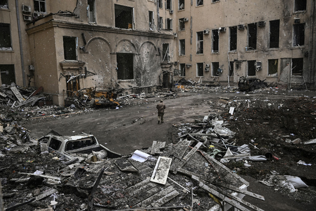 An Ukranian serviceman walks between rubble of the destroyed regional headquarters of Kharkiv on Sunday (AFP photo)