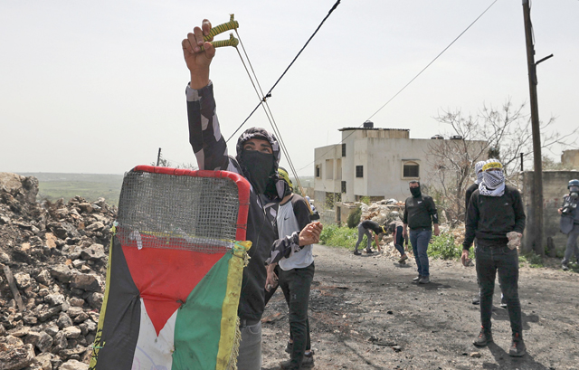 Palestinians, demonstrating against the expropriation of land by Israel, clash with Israeli occupation forces in the village of Kfar Qaddum near the Jewish settlement of Kedumim in the occupied West Bank, on Friday (AFP photo)