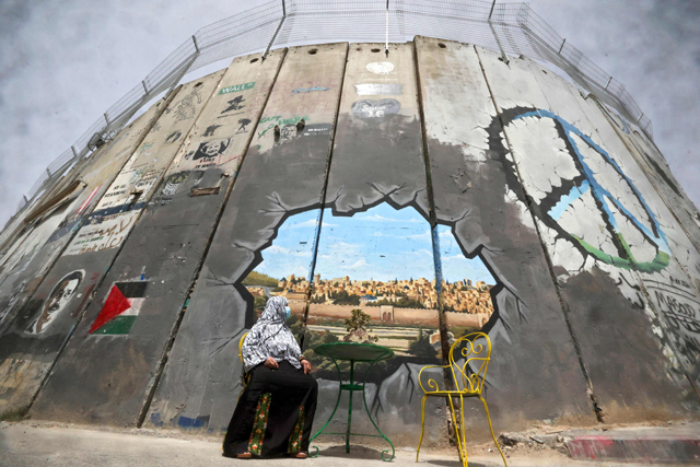 A Palestinian woman looks at a mural depicting Al Aqsa Mosque compound and Jerusalem's old city on Israel's controversial separation barrier between Jerusalem and the occupied West Bank, in Bethlehem, on Sunday (AFP photo)