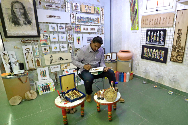 Sudanese artist Mutaz Al Fateh paints with colours derived from natural material, at his gallery in Khartoum, on April 15 (AFP photo)