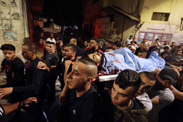 Men carry the body of Bilal Kabha to Jenin hospital after he was killed during confrontations in Yabad village, near Jenin, in the Israeli-occupied West Bank (AFP photo)