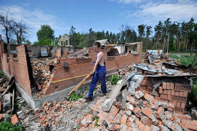 A man cleans up debris of his house destroyed by shelling in the village of Moshchun, Kyiv region, on Thursday on the 99th day of the Russian invasion of Ukraine (AFP photo)