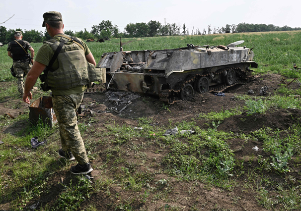 Ukrainian servicemen walk past a destroyed Russian military vehicles on a field not far of the southern city of Mykolaiv on Sunday, amid the Russian invasion of Ukraine (AFP photo)