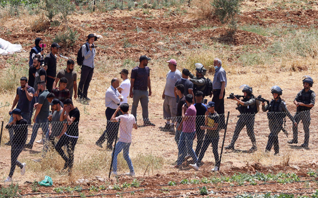 Palestinian demonstrators confront Israeli forces while protesting attempts by Israeli settlers from the settlement of Eli to reportedly take control of a water spring in the village of Qaryut, south of Nablus in the occupied West Bank, on Friday (AFP photo)
