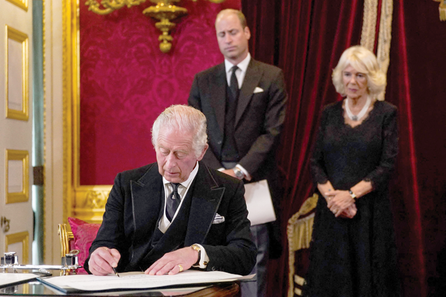 Britain's Prince William, Prince of Wales (centre) and Britain's Camilla, Queen Consort (right) watch as Britain's King Charles III signs an oath to uphold the security of the Church in Scotland, during a meeting of the Accession Council inside St James's Palace in London on Saturday, to proclaim him as the new King (AFP photo)