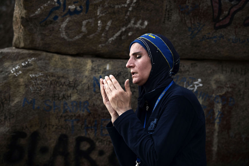 A pilgrim prays as she visits the Hiraa cave on Noor Mountain on Saturday (AFP photo)