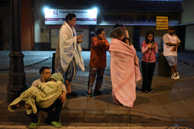 Residents stand in a street after a 6.8-magnitude earthquake in Mexico City on Thursday (AFP photo)