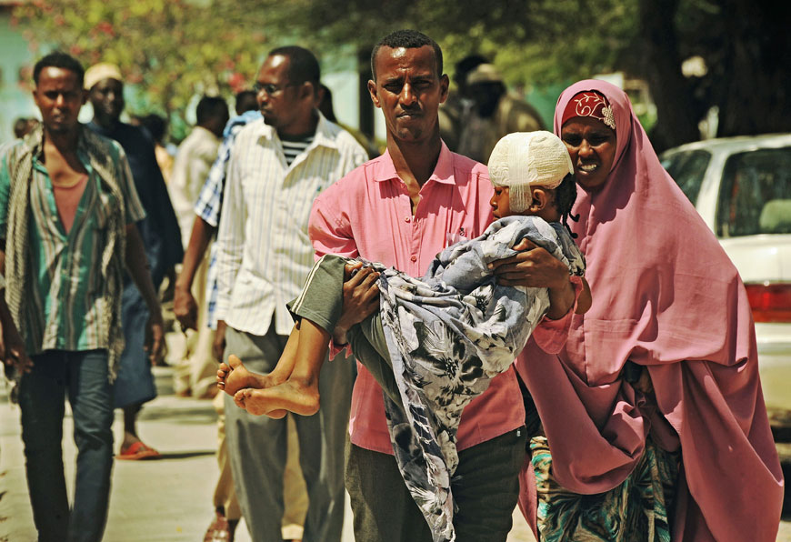A man carries an injured Somali child to Madina hospital on Tuesday following a car bomb attack late on Monday (AFP photo)