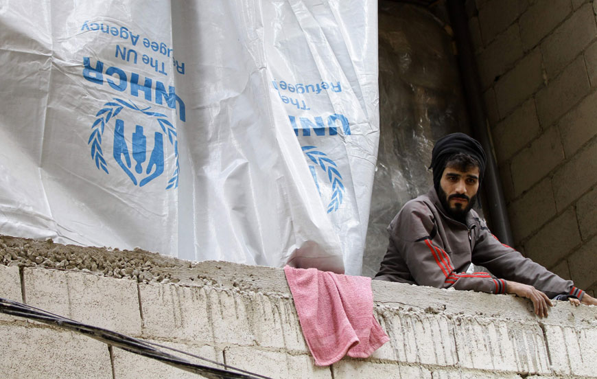 Syrian man looks on from inside an unfinished building where he lives with his family in the Daf Al Sakhr neighbourhood of Jaramana on the outskirts of the Syrian capital Damascus on December 16 (AFP photo)