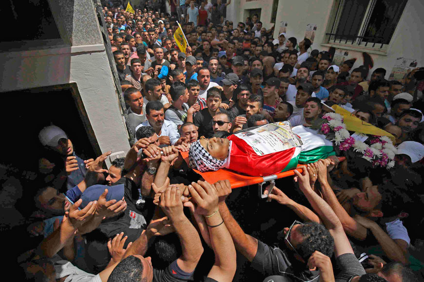 Mourners carry the body of Palestinian Mohammad Abu Latifa during his funeral in Qalandiya refugee camp, near the West Bank city of Ramallah, on Monday (Reuters photo)