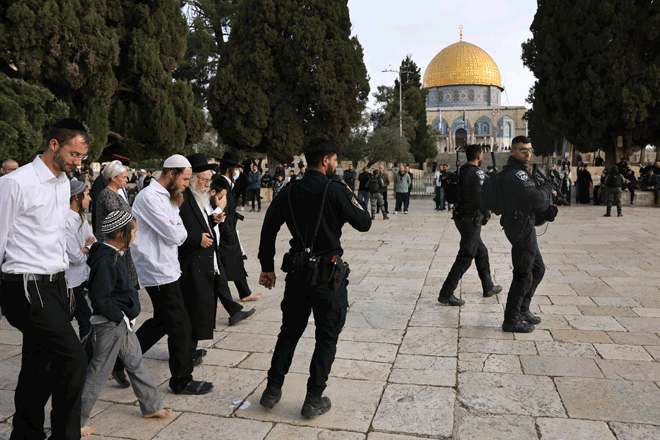 Jewish worshippers walk protected by Israeli forces into Al Aqsa Mosque compound, also known as the Temple Mount complex to Jews, in Jerusalem on Sunday, during the Muslim holy fasting month of Ramadan, which also coincides with the Jewish Passover holiday (AFP photo)