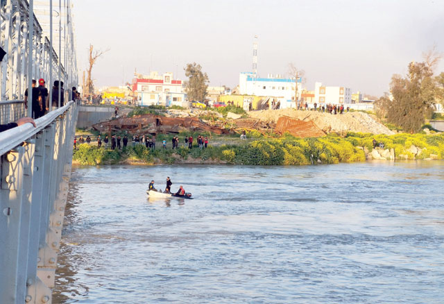 Iraqi rescuers search for survivors at the site where an overloaded ferry sank in the Tigris River near Mosul in Iraq on Thursday (Reuters photo)