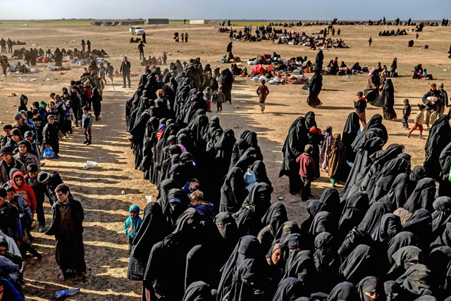 Civilians evacuated from the Daesh group's embattled holdout of Baghouz wait at a screening area held by the US-backed Kurdish-led Syrian Democratic Forces, in the eastern Syrian province of Deir Ezzor, on Tuesday (AFP photo)