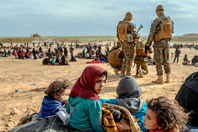 Civilians evacuated from the Daesh group's embattled holdout of Baghouz wait at a screening area held by the US-backed Kurdish-led Syrian Democratic Forces, in the eastern Syrian province of Deir Ezzor, on Tuesday (AFP photo)