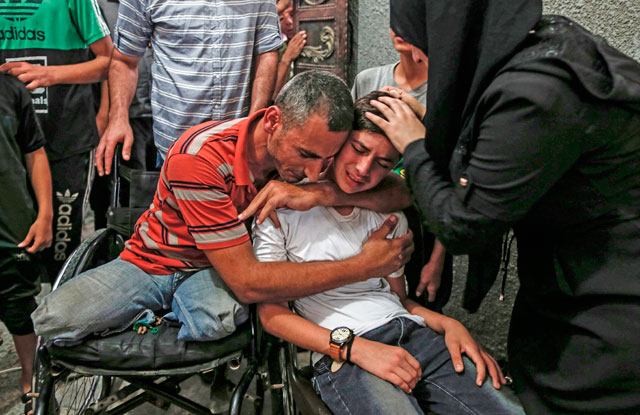   Relatives of 17-year-old Ali Al Ashqar, one of the two Palestinian youths killed yesterday by Israeli fire, mourn during his funeral at Jabaliya refugee camp in the northern Gaza Strip on Saturday (AFP photo)