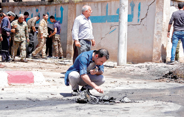 A member of the Kurdish security examines debris at the site of an explosive-rigged vehicle that detonated in the town of Al Qahtaniyah, in the Hasakeh province, on Wednesday  (AFP photo)