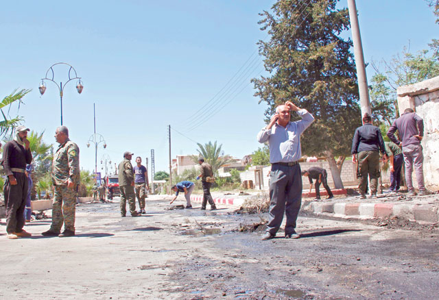 Kurdish security forces stand guard at the site of an explosive-rigged vehicle that detonated in the town of Al Qahtaniyah, in the Hasakeh province, on Wednesday (AFP photo)