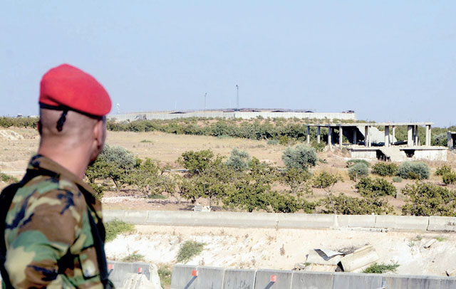 A member of the Syrian regime forces stares at a Turkish observation post in the town of Morek in the northern countryside of Hama province on August 24 (AFP photo)