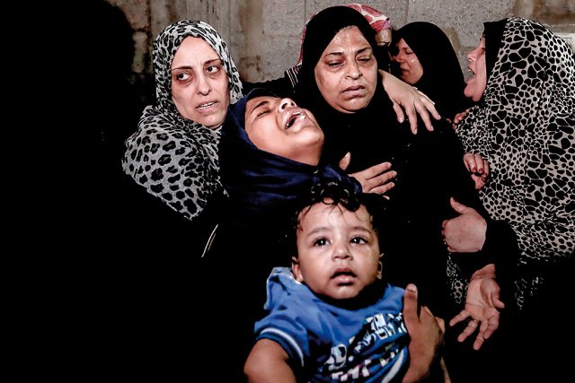 Palestinian relatives of Ahmad Murjan, the young Hamas fighter killed by Israeli fire, mourn over his death during the funeral in Jabalia, in the northern Gaza Strip, on Tuesday (AFP photo)
