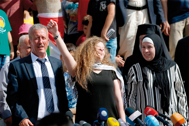 Palestinian activist and campaigner Ahed Tamimi (centre) celebrates her release from prison as she stands between her father (left) and mother, during a press conference in the West Bank village of Nabi Saleh, on Sunday (AFP photo)