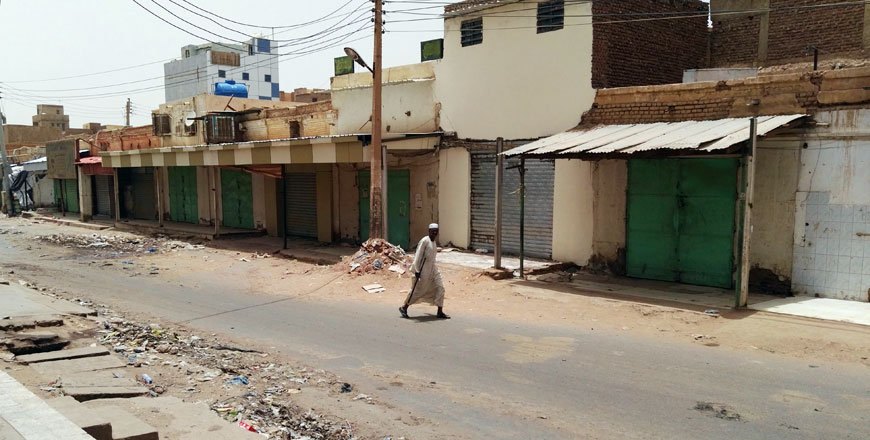 A Sudanese man walks past closed shops in a deserted street in Khartoum's twin city Omdurman on the first day of a civil disobedience campaign across Sudan on Sunday (AFP photo)