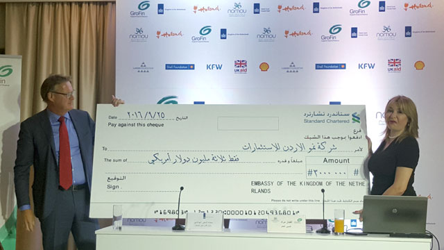 Dutch Ambassador Paul van den IJseel presents a cheque to GroFin-Jordan General Manager Alfinaz Murad in Amman on Sunday (Photo by Laila Azzeh)