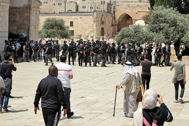   Palestinians stand near Israeli forces as clashes erupted with Palestinians on Al Haram Al Sharif/Al Aqsa Mosque compound, in occupied Jerusalem's Old City on Sunday (Reuters photo)