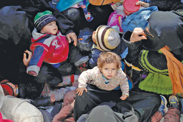 Civilians fleeing the battered Daesh-held holdout of Baghouz in the eastern Syrian province of Deir Ezzor sit in the back of a truck on Monday  (AFP photo)
